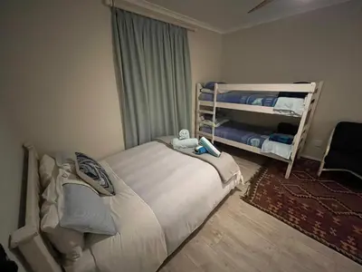 a bedroom with a bed and a bunk bed at Sea front Rocky Pools in Bettyʼs Bay