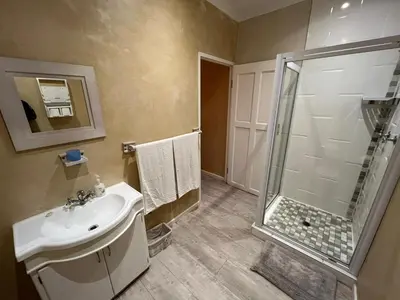 a bathroom with a shower and a sink at Sea front Rocky Pools in Bettyʼs Bay