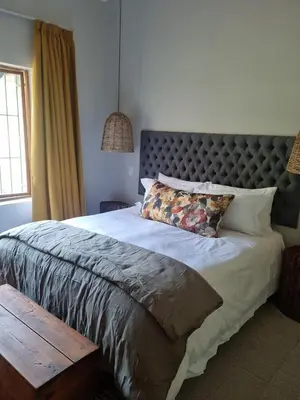 a bedroom with a large bed with a large headboard at River Edge in Romansrivier
