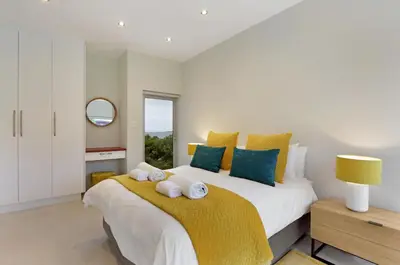 a bedroom with a large bed with towels on it at Blueview on Silversand in Clareport