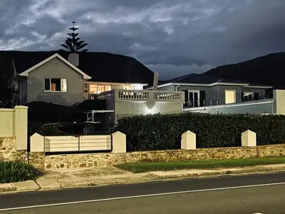 a house on the side of a street with a fence at Villa Voigt in Hermanus