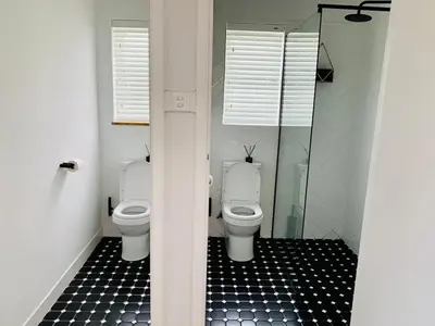 a bathroom with two toilets and a glass shower at Villa Voigt in Hermanus