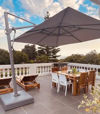 an umbrella on a patio with a table and chairs at Villa Voigt in Hermanus