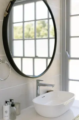 a bathroom with a white sink and a mirror at La Roche Estate in Franschhoek