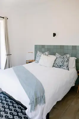 a bedroom with a large white bed with pillows at La Roche Estate in Franschhoek