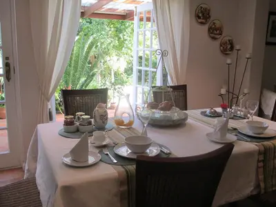a dining room table with a white table cloth with food on it at Invergara in Cape Town