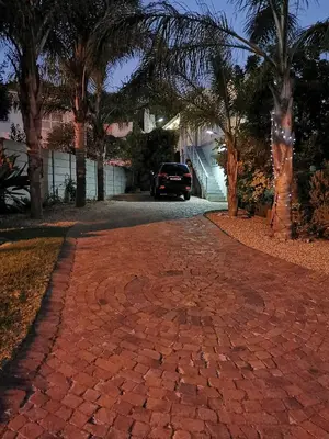 a brick driveway with a car parked on a street at Protea Suite in Bellville