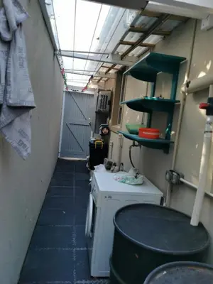 a small kitchen with a washing machine in a trailer at Protea Suite in Bellville