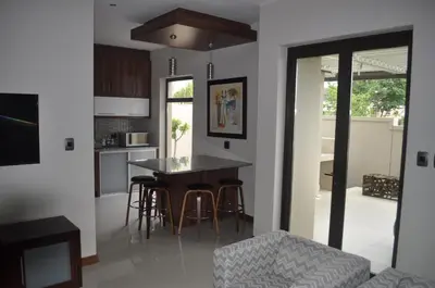 a kitchen with a table and some stools in it at A Perfect Self Catering in Wellington