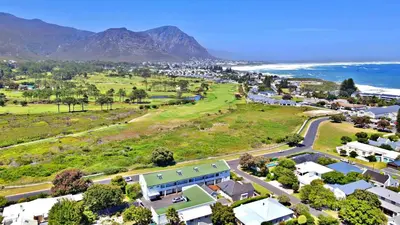 an aerial view of a town with the ocean and mountains at Fairway Holiday Accommodation in Hermanus