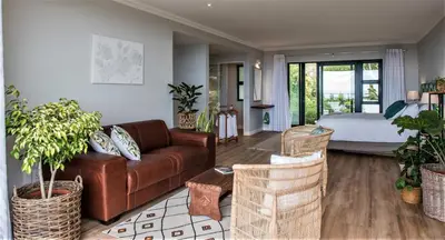 a living room with a couch and a bed at Ridge House in Hermanus