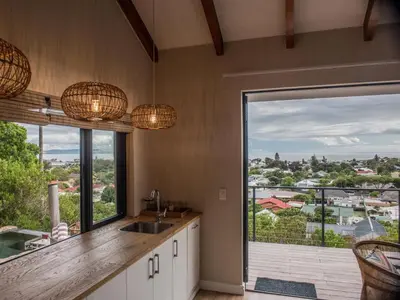 a kitchen with a sink and a large window at Ridge House in Hermanus