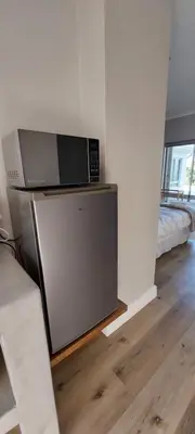 a microwave sitting on top of a refrigerator in a room at Kortrijk Paarl Self Catering in Paarl