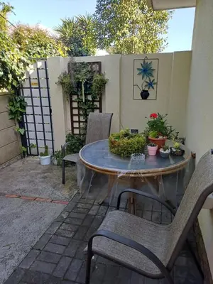 a patio with a table with chairs and plants at La Grâce, Durbanville in Cape Town