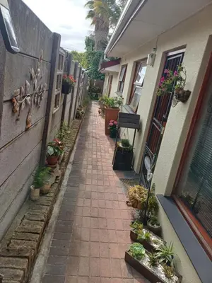 an alley with potted plants on the side of a building at La Grâce, Durbanville in Cape Town
