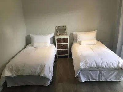 two beds sitting next to each other in a room at Olive Cottage in Hermanus