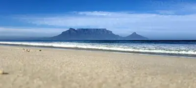 a view of a beach with a mountain in the background at Cozy Cottage +/- 500m from the beach in Cape Town