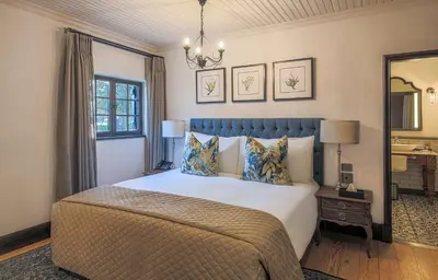 a bedroom with a large bed and a mirror at Southern Sun de Wagen in Stellenbosch