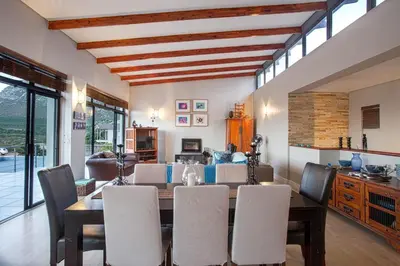 a dining room with a table and chairs at Gecko House in Pringle Bay