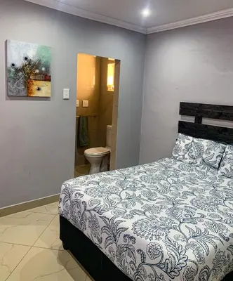 a bedroom with a bed and a bathroom at ALIAHIDI in Cape Town