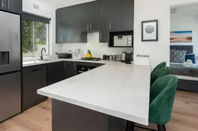 a kitchen with black cabinets and a white counter top at 64 Whalerock Estate in Hermanus