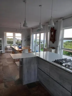 a kitchen with a counter and a table with a stove at Thundering waves in Bettyʼs Bay
