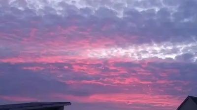 a cloudy sky at sunset with a red at Thundering waves in Bettyʼs Bay