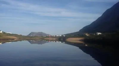 a view of a lake with mountains in the background at Thundering waves in Bettyʼs Bay
