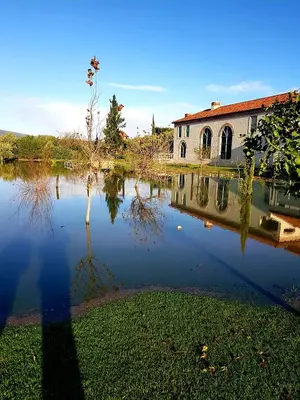 a house sitting next to a large body of water at Sandmartins Private Secure Villa in Simondium