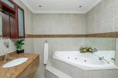 a bathroom with a tub and a sink at The Model House in Cape Town