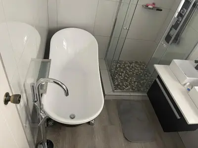 a bathroom with a shower and a toilet and a sink at Jackie’s 3 bedroomed secure beach front apartment Strand Golden Mile in Strand