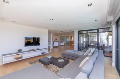 a large living room with a couch and a tv at Villa Paradis - ocean front with views to behold! in Cape Town