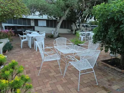 a group of white tables and chairs on a patio at On The Beach At Strand in Strand
