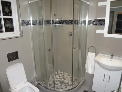 a bathroom with a shower and a toilet and a sink at Zebra Place in Cape Town