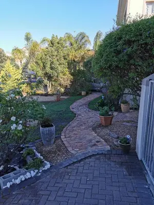 a garden with a brick walkway in a yard at Zebra Place in Cape Town