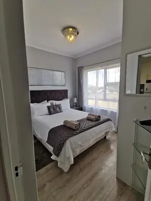 a bedroom with a large bed and a window at Zebra Place in Cape Town