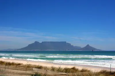 a beach with mountains in the background and the ocean at Waters Breakaway in Bloubergstrand