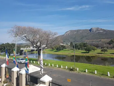 a car parked in a parking lot next to a river at Sunset Boulevard Riverlodge in Paarl