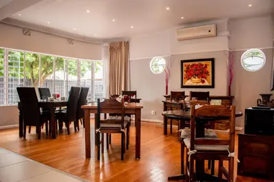 a dining room with wooden tables and chairs at Balmoral Lodge in Bellville
