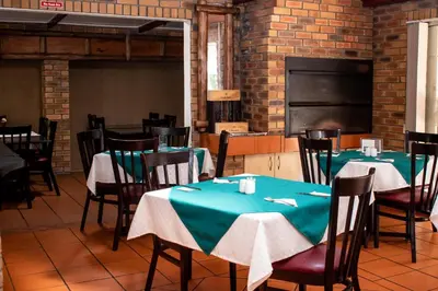 a dining room with tables and chairs and a chalkboard at Balmoral Lodge in Bellville