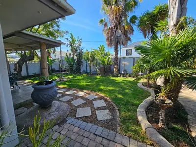 a backyard with a garden with palm trees at Balmoral Lodge in Bellville