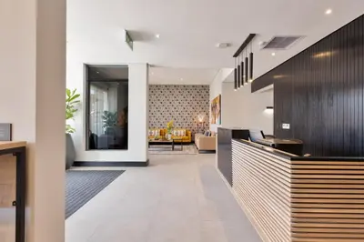 a lobby with a reception desk and a living room at Hotel Krige in Stellenbosch
