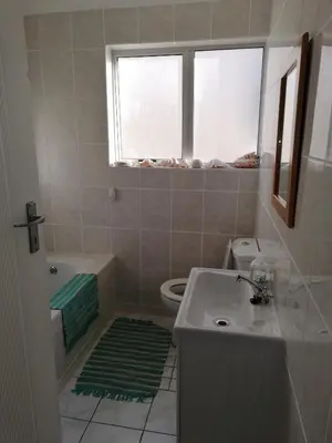 a bathroom with a sink and a toilet and a window at Ocean View in Hermanus