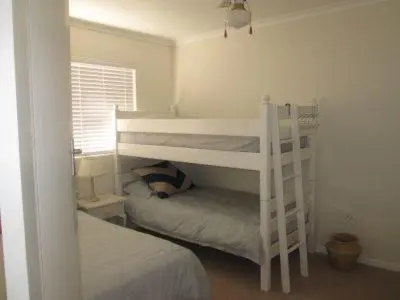 a bedroom with two bunk beds and a ladder at Ocean View in Hermanus