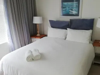 a hotel room with a white bed with towels on it at Ocean View in Hermanus