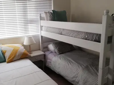 a bedroom with two bunk beds and a lamp at Ocean View in Hermanus