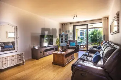 a living room with a couch and a tv at Portifino On Lake G16 The Island Club in Cape Town