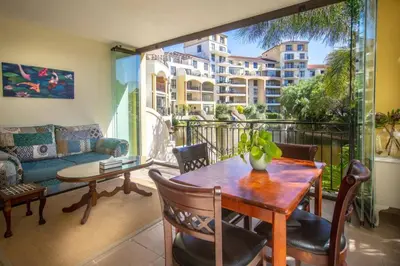 a living room with a table and a couch at Portifino On Lake G16 The Island Club in Cape Town