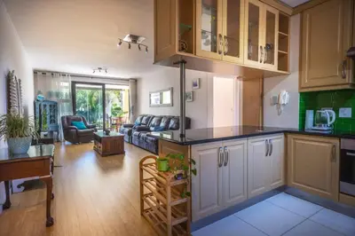 a kitchen and a living room with a couch at Portifino On Lake G16 The Island Club in Cape Town