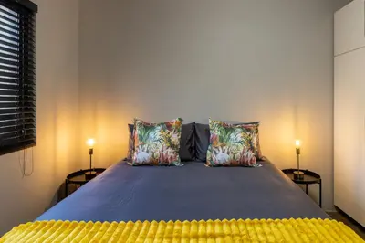 a bedroom with a large bed with two lamps at Steenbok farm cottages -Mongoose cottage in Wolseley